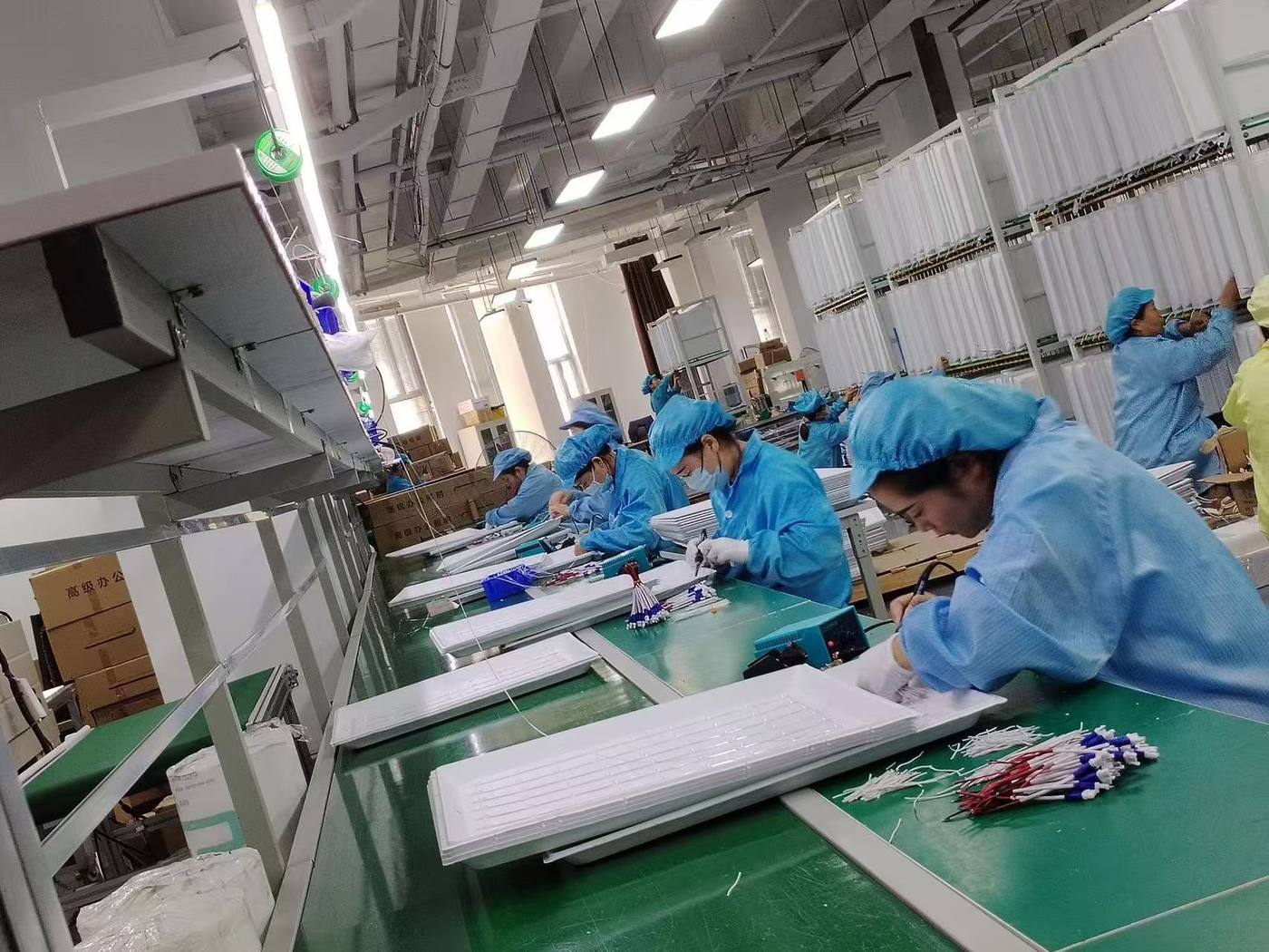 Workshop team assembling lighting fixtures on a production line